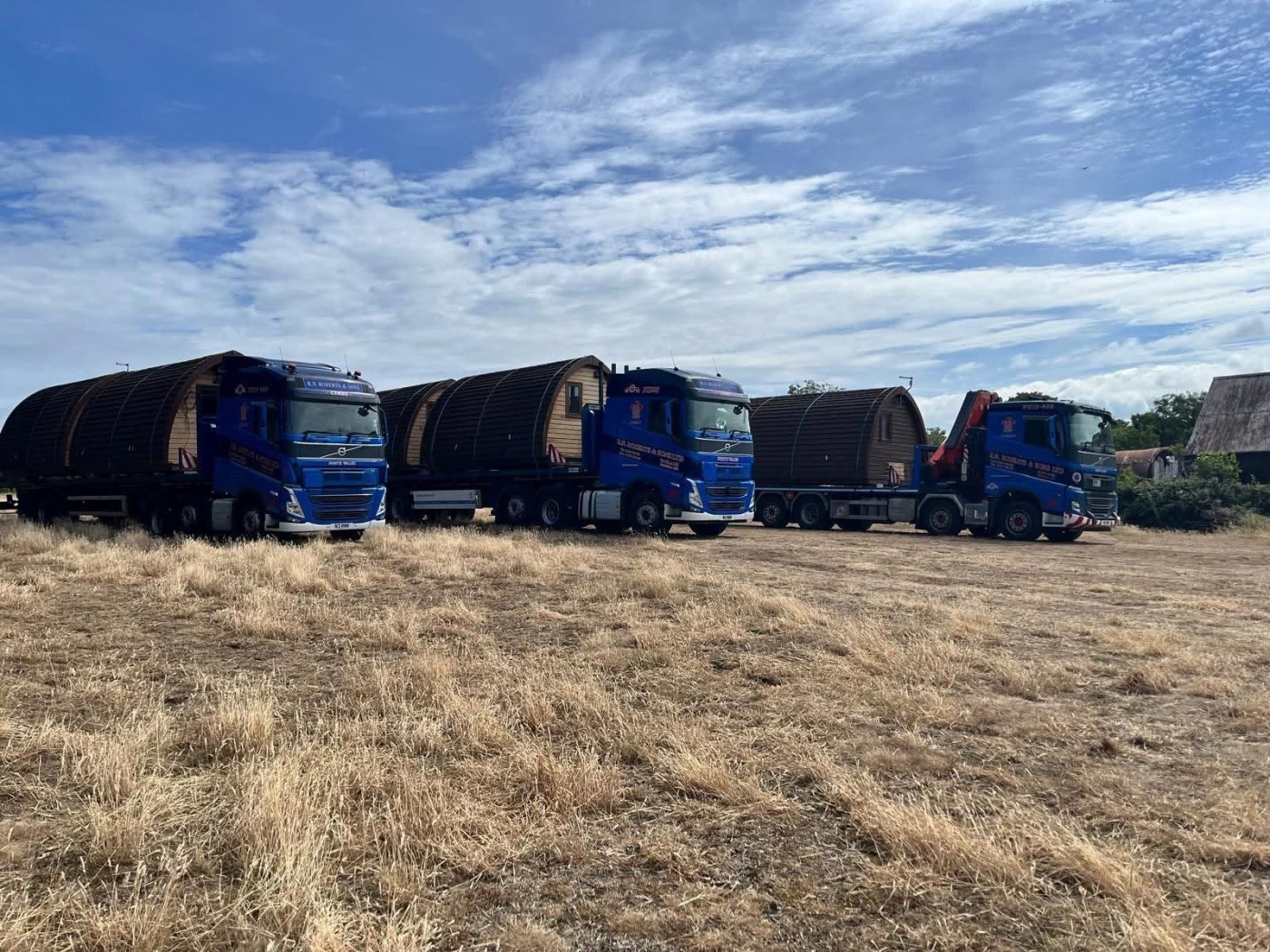 Three RN Roberts trucks carrying oversized timber cabins across North Wales