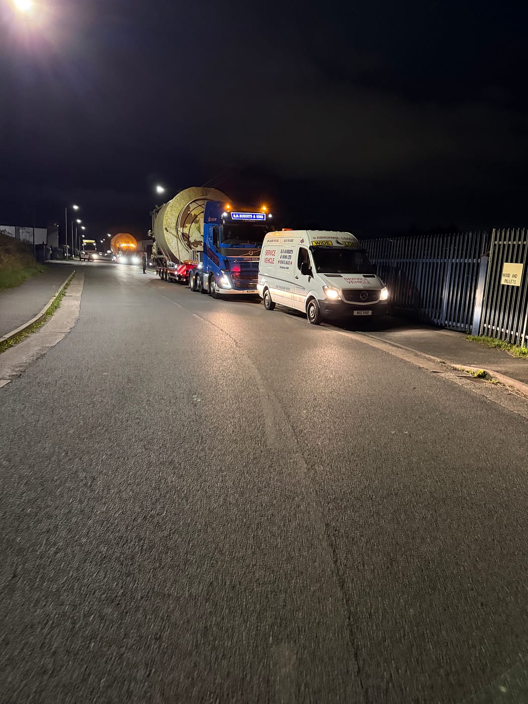RN Roberts escort van with wide load signage leading an abnormal load at night