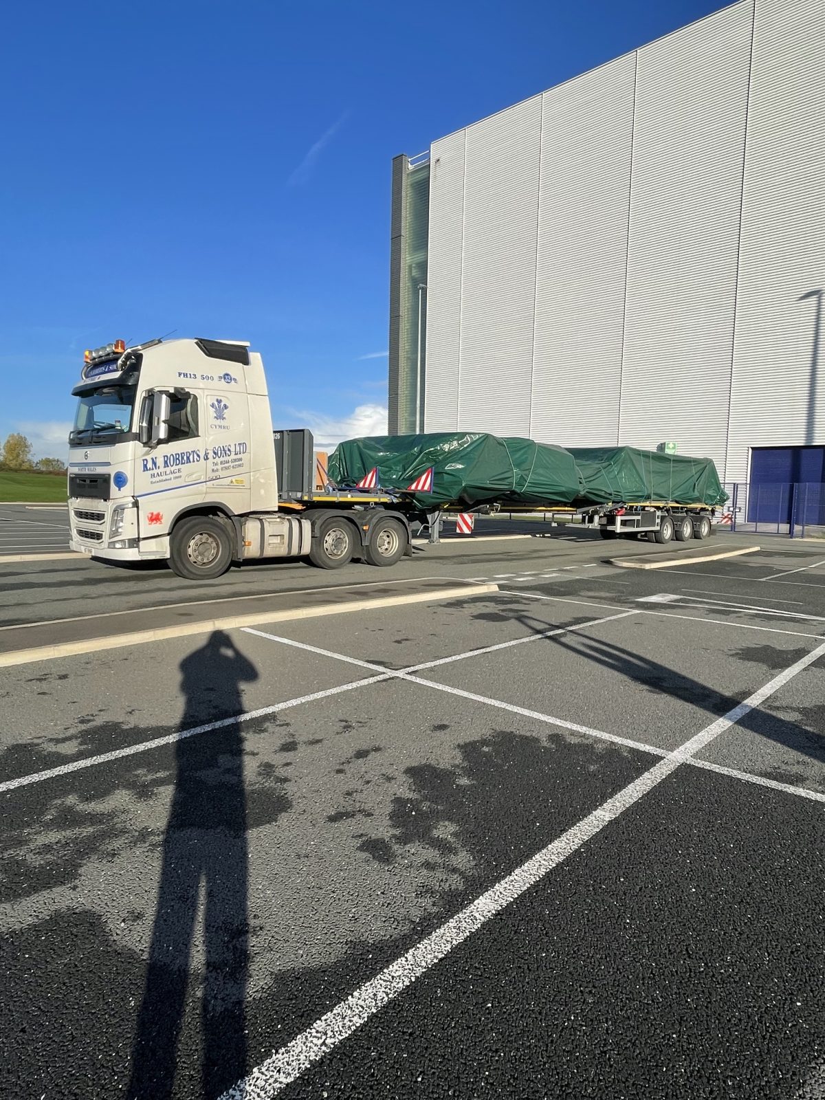 RN Roberts extendable flatbed trailer carrying a long sheeted load