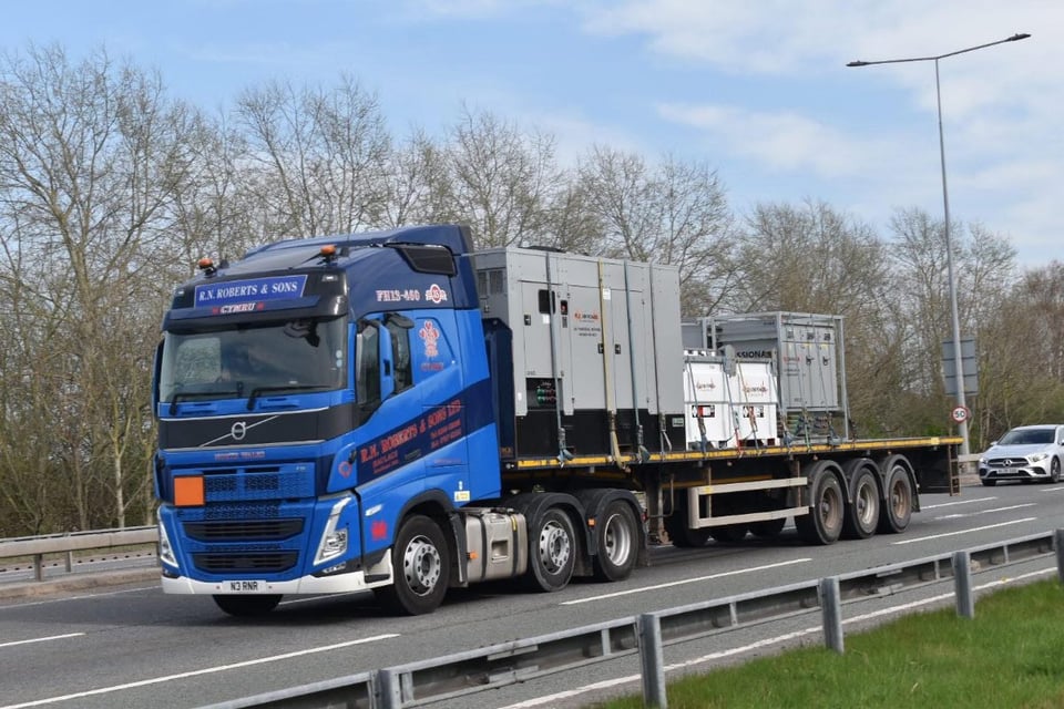 RN Roberts flatbed lorry carrying generators on the road