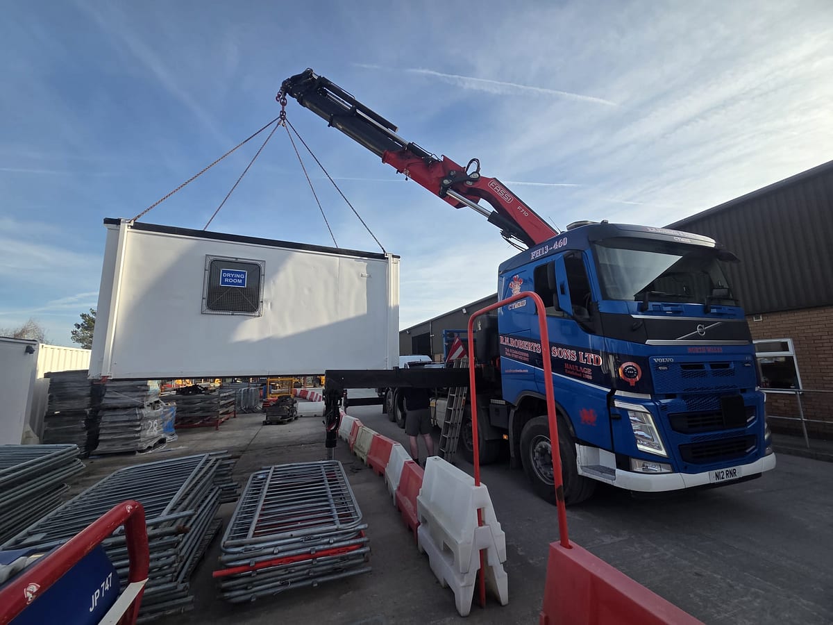 RN Roberts HIAB lorry lifting a welfare cabin on site