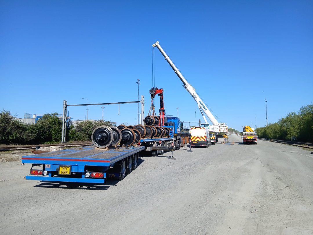 RN Roberts HIAB lorry loading railway wheelsets alongside the tracks, working with a mobile crane