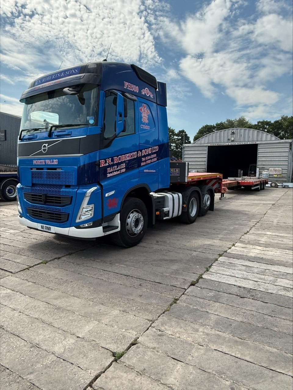 RN Roberts Volvo tractor unit coupled to a step extender low loader trailer at the depot