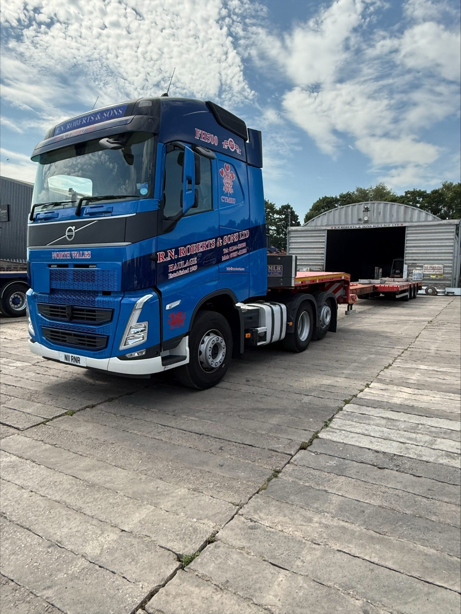 RN Roberts Volvo tractor unit coupled to a step extender low loader trailer at the depot